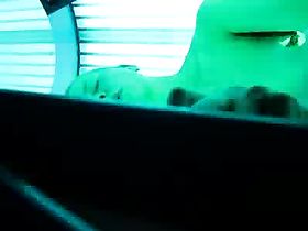 Худая и стройная телка стоит в кабинке солярия и загорает абсолютно голой