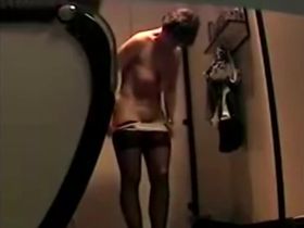 Одна  женщина переодевается в кабинке не подозревая о камере из под низа