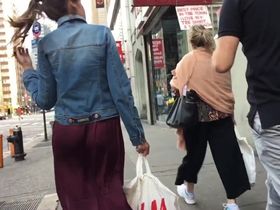 Длинная юбка девки с хвостиком во время ходьбы залезает между её упругих ягодиц